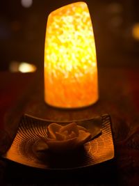 Close-up of lit candle on table