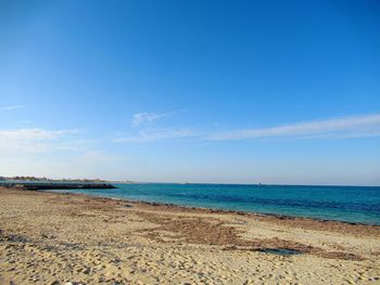 Scenic view of beach against blue sky