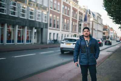 Portrait of young man standing in city