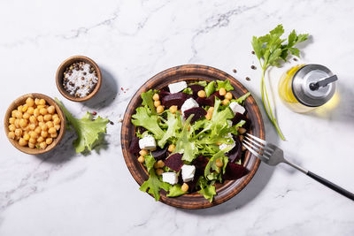 Healthy spring salad beet with spinach, cheese feta and chickpeas on a marble tabletop. 