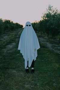 Rear view of woman standing on field against clear sky