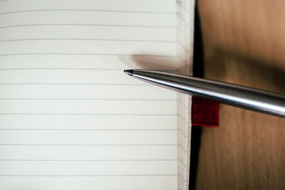 Close-up of pen with open diary on table