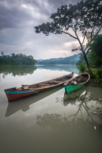 Boats moored on shore against sky