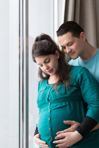 Young couple standing against wall