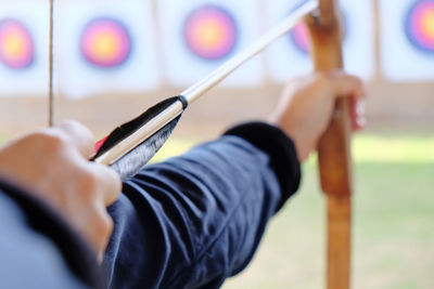 Close-up of person aiming bow