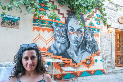Portrait of young woman against building