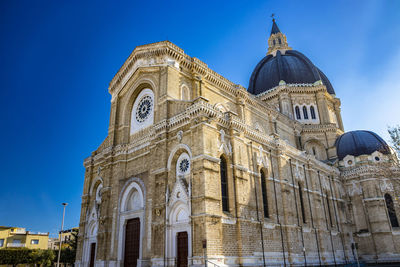 Low angle view of historic building against blue sky