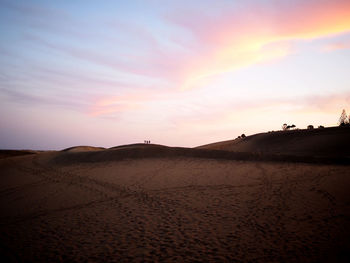 Scenic view of desert against sky during sunset