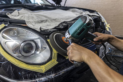 Cropped hand of man repairing car