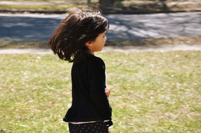 Side view of cute girl running on field