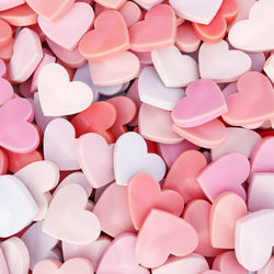 3d rendering of pile of pinkish and redish heart-shaped candies viewed from above