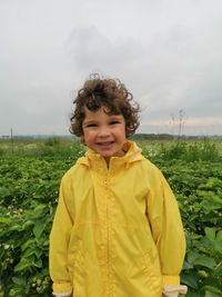 Cute boy smiles at strawberry field