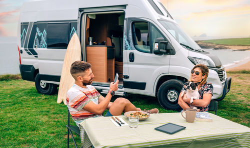 Couple with dog sitting outdoors