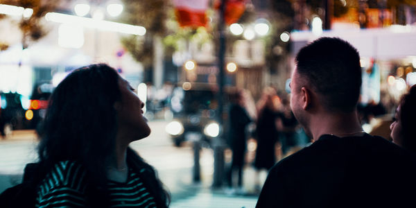 Rear view of people on street in city at night