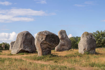 Rocks on field against sky