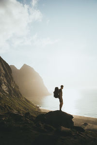 High angle view of man standing on rock against sea