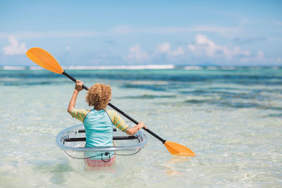 Rear view of person in sea against sky