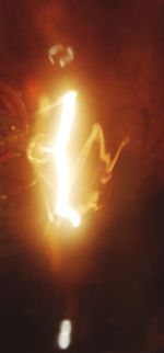 Close-up of illuminated fire against sky at night