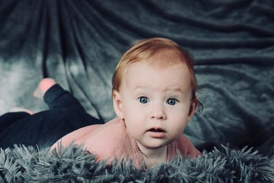 Portrait of cute baby lying on bed