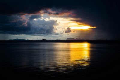Scenic view of sea against cloudy sky at sunset