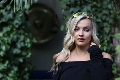 Portrait of woman standing against plants
