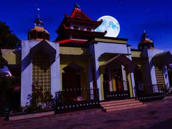 Low angle view of illuminated building against sky at night