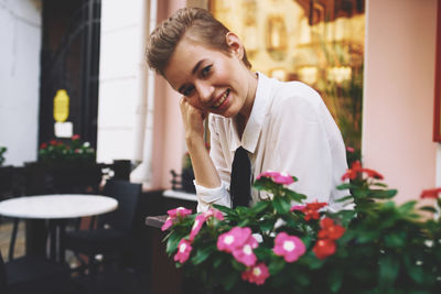 Side view of young woman sitting on table