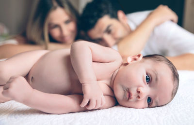 Portrait of cute baby lying on bed at home