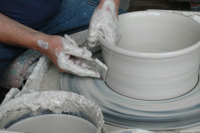 Midsection of man making pots