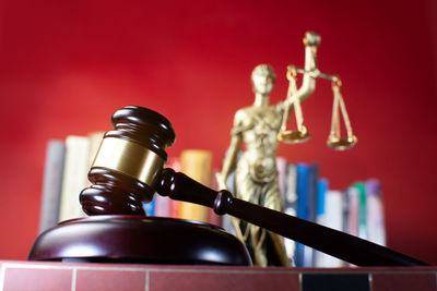 Lady justice statue with judge gavel in front and books in the background