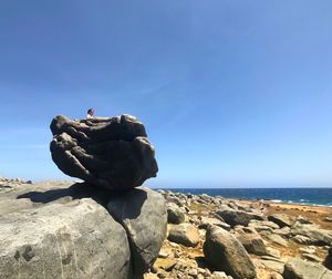 Sculpture on rock by sea against sky