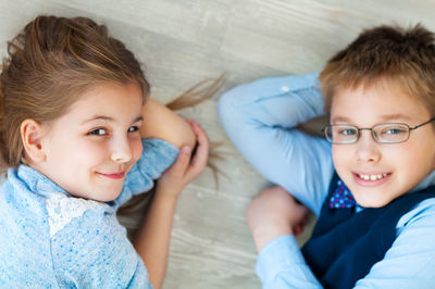 Boy and girl lying on floor at home