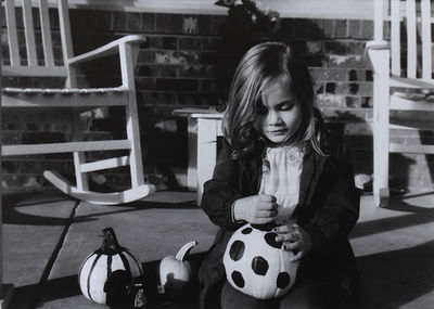 Girl with painted pumpkin by bench