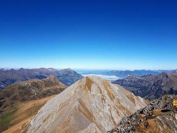 Scenic view of mountains against clear blue sky