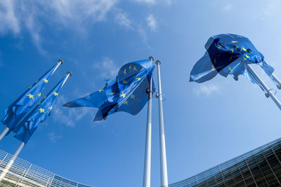 Low angle view of flags against blue sky