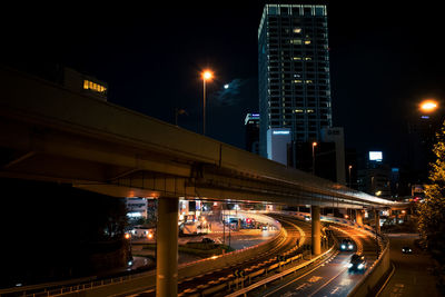 Light trails on city street against sky at night