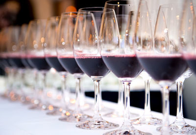 Close-up of wineglass in row on table