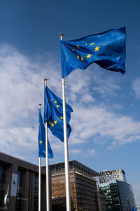 Low angle view of flag flags against buildings