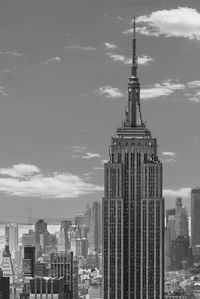 Buildings in city against cloudy sky