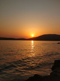 Scenic view of sea against orange sky