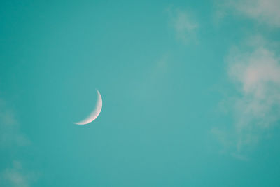 Low angle view of moon in blue sky