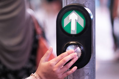 Cropped hand pressing button on road signal