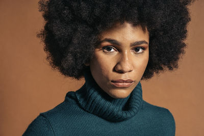 Close-up portrait of young woman against gray background