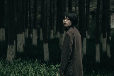 Side view of young woman in forest