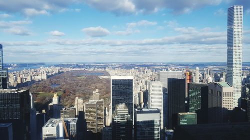 Aerial view of cityscape against cloudy sky