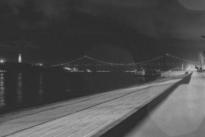 Bridge over illuminated city against sky at night