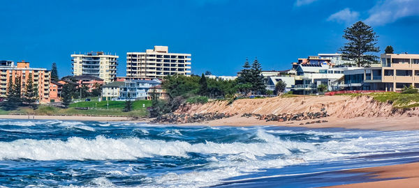 Buildings by sea against sky in city