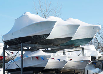 Low angle view of boats moored against blue sky