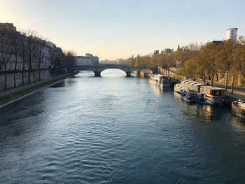 Bridge over river in city against clear sky
