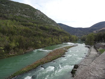 Scenic view of river amidst mountains against sky